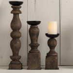 A set of three Hand-Turned Pillar Candle Holders in various sizes, showcasing natural wood tones and black metal cups.
