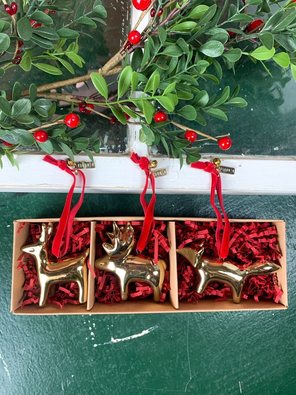 Set of three gold woodland animal ornaments in a box with red filler