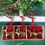 Set of three gold woodland animal ornaments in a box with red filler