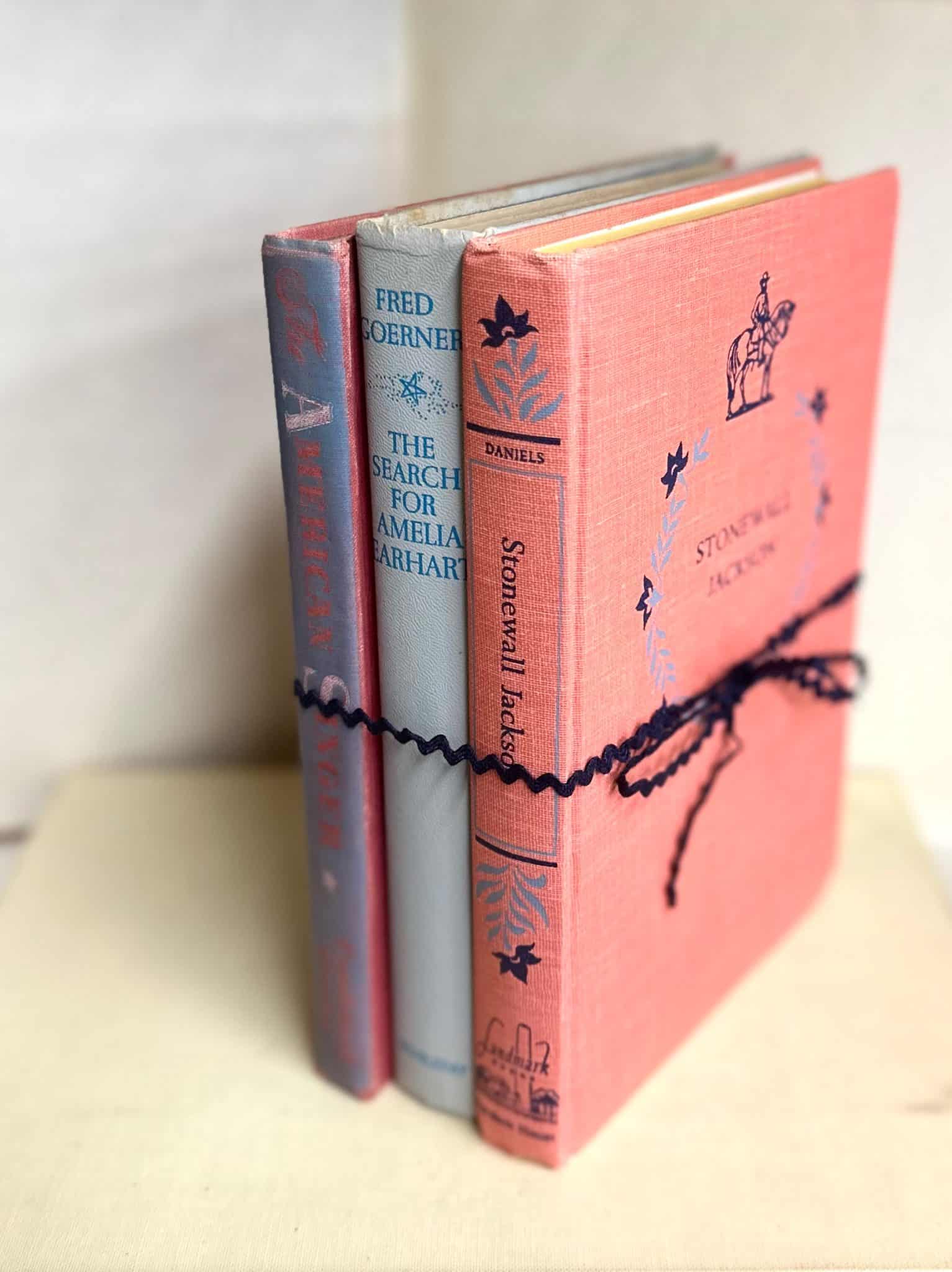 Vintage book bundle with playful, colorful covers and a navy ribbon