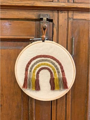 Embroidery Wall Hanging Rainbow straight on view against wood