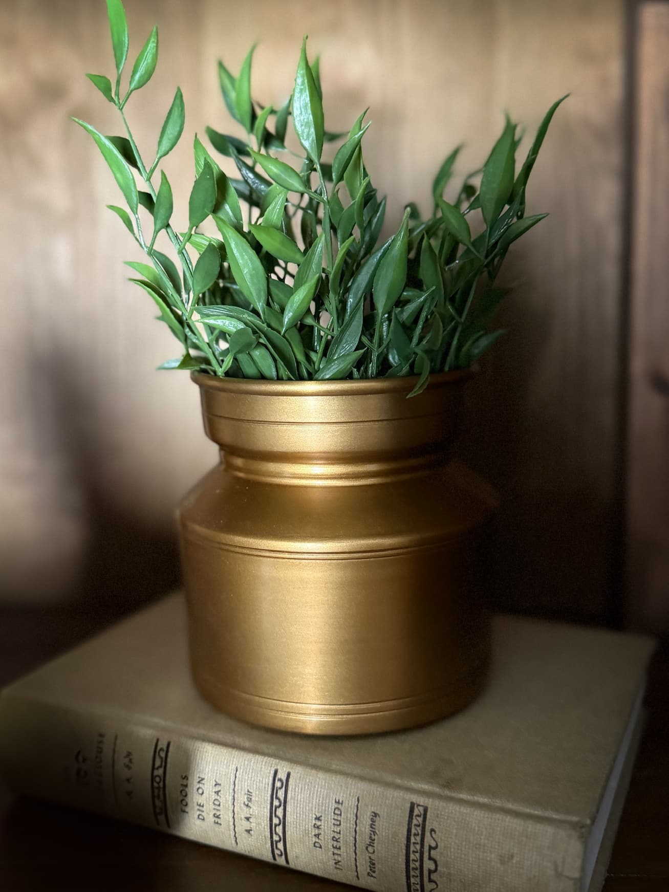 Brass Lota Vase Oblong in shelf on book with greenery straight on view
