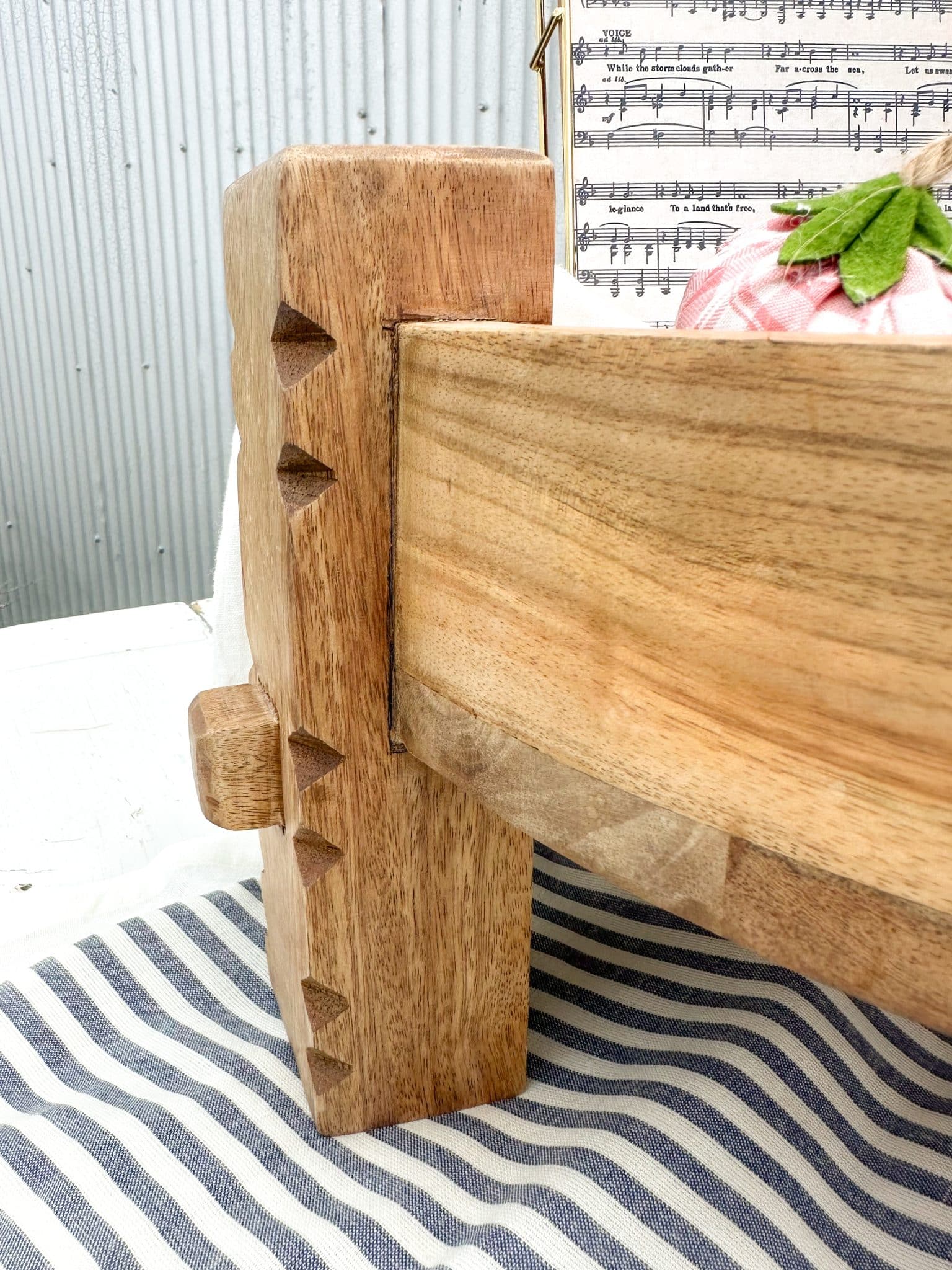 Side view of the carved wooden leg and corner joinery on the wood chakki table pedestal, showing traditional design and craftsmanship.