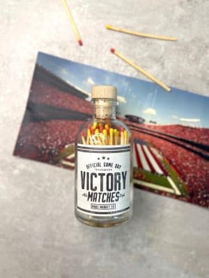 KC Chiefs Victory Matches jar on a concrete background with stadium photo and scattered matches