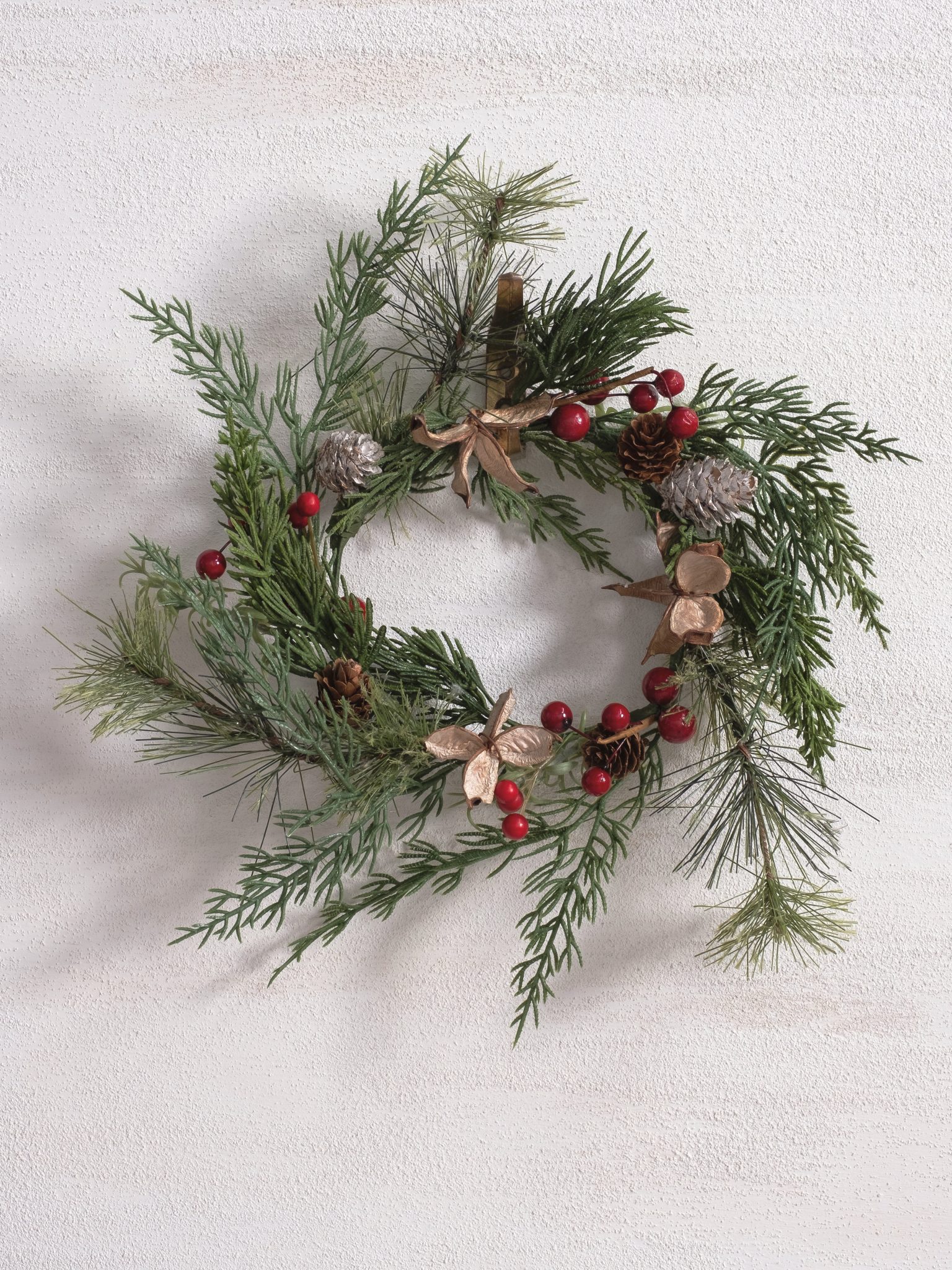 Mini faux greenery wreath featuring pine branches, pinecones, berries, and soft botanical accents.