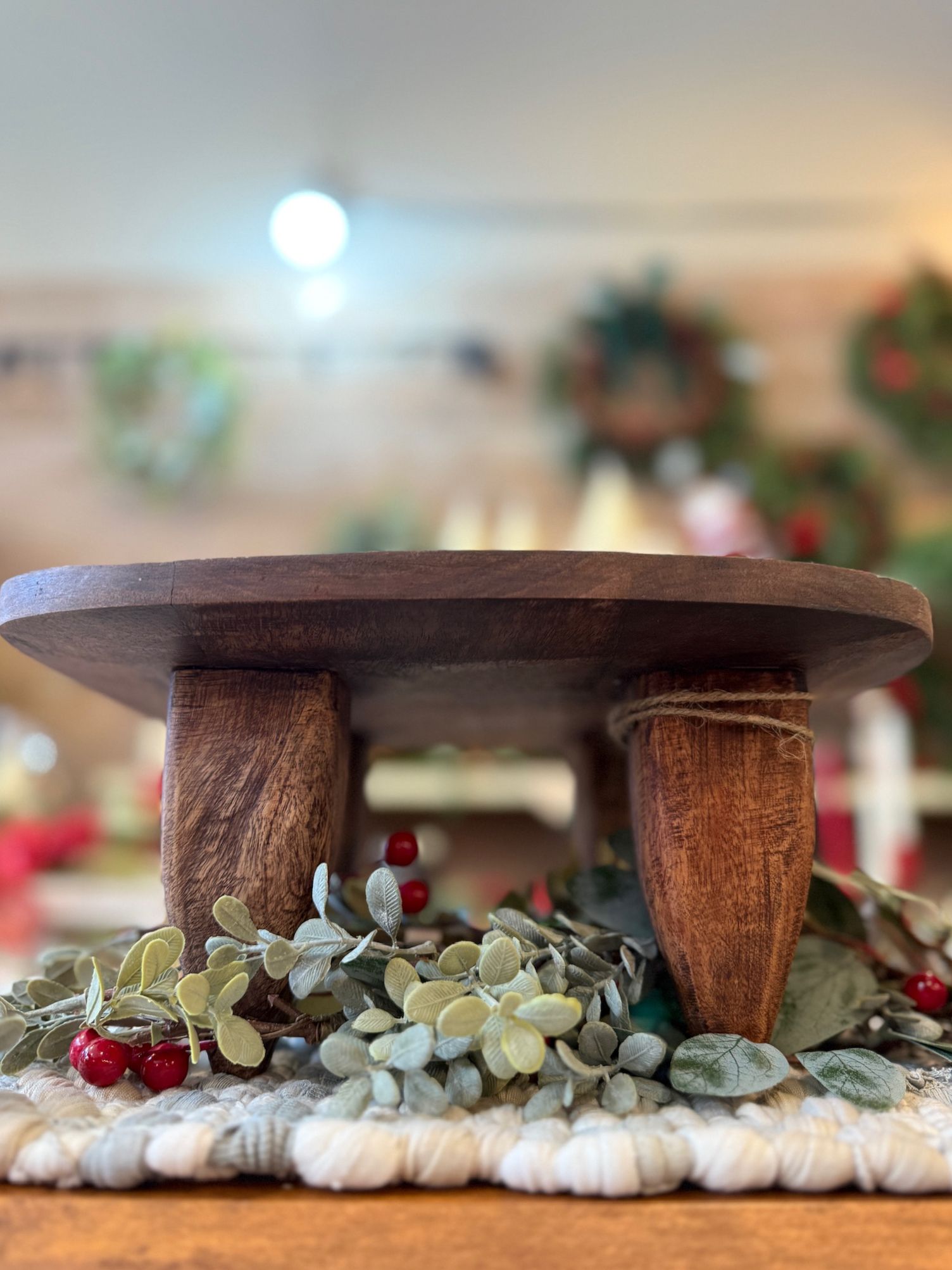 Side view of the Square Wood Primitive Stool focusing on its carved primitive legs and aged wood texture.
