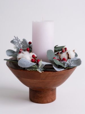 Footed mango wood bowl styled with a winter candle ring featuring faux greenery, berries, and cotton stems.