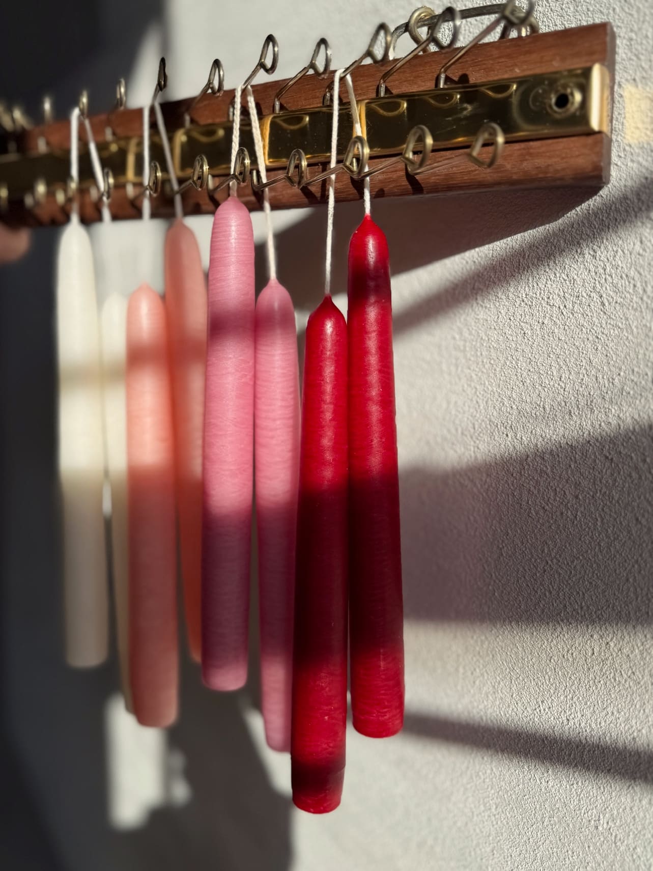 Hanging Our Taper Candles in a valentine color mix, styled in warm sunlight.