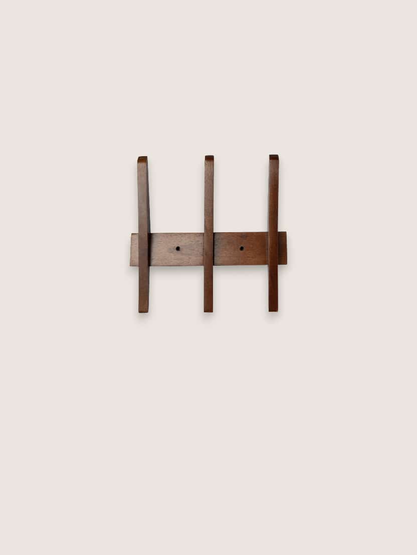 Small wood hanging wall rack with three curved pegs in a warm walnut finish, shown front-facing on a neutral background.
